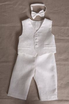 "Baby boy white linen outfit includes SET of 4 : - Vest - Pants - Shirt - Bow tie Shirt, pants and bow tie are made of linen. Vest made of eight-point star pattern linen cotton. The vest is fully lined with cotton fabric. Pants come in elastic waist adjustable with buttons and the bow tie is pre-tied with adjustable Velcro closure on the back. There is an available short or long sleeve shirt. If not specified there will be made long sleeve shirt as seen in the photo. You can order the appropriat Elegant White Linen Sets, Classic White Linen Set, Elegant White Suits For Baptism, Formal White Linen Sets, White Linen Formal Sets, Baby Boy White Outfit, Formal Boys Outfit, White Linen Outfit, Natural Clothes