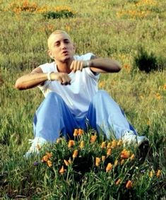 a man sitting in the grass with his arms crossed