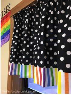 black and white polka dot curtains hanging from a wooden rail in front of a window