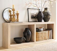 a shelf with vases and other items on top of it in a living room