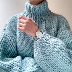 a woman wearing a blue sweater and watch