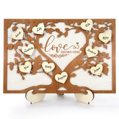 a wooden family tree with hearts and names engraved on the leaves, in white background