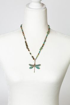 Seasons change, and so do we - the dragonfly has long been a symbol of renewal and change. Hues of green and blues in turquoise, crystal, and Czech glass create warmth in this unique handmade collage necklace, finished with a patina dragonfly focal. The perfect addition to your designer jewelry collection. Antique brass (lead- and nickel-free) Czech glass, Turquoise, Crystal 20.5-22.5" adjustable length, lobster claw clasp We hand select our natural materials, thus there may be slight variations in color and/or size that will not detract from the overall aesthetic Our unique handcrafted designer jewelry for women is made in America, each design created individually in our personal design studio in Floyd VA USA Bohemian Handmade Dragonfly Necklace, Handmade Green Dragonfly Jewelry, Handmade Bohemian Dragonfly Necklace, Collage Necklace, Floyd Va, Designers Jewelry Collection, Handmade Collage, Designer Handmade Jewellery, Dragonfly Necklace