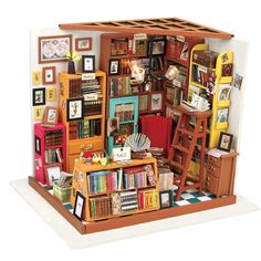 a doll house with bookshelves, ladders and pictures on the wall behind it