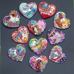 several heart shaped brooches are arranged on a table