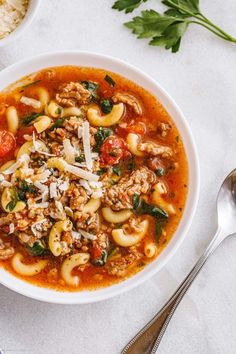 a white bowl filled with pasta and meat soup