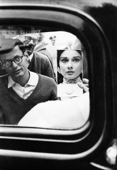 a man and woman are seen in the rear view mirror of an old car as they look at each other