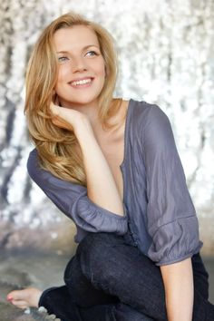 a woman sitting on the ground posing for a photo