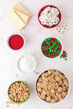 the ingredients to make christmas crackers are displayed in bowls on a marble countertop