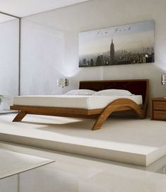 a modern bedroom with white walls and flooring, including a bed frame that is made out of wood