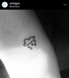 a black and white photo of a cloud with rain drops on the side of a woman's leg