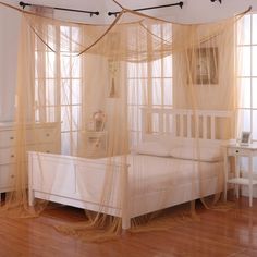 a white bed sitting in a bedroom on top of a hard wood floor