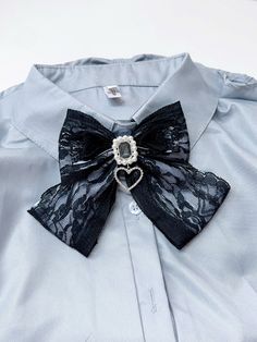 a blue shirt with a black bow tie and brooch attached to the front of it