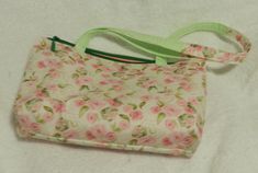 "Shoulder Bag with Pink Flowers and Green Leaves The bag has pink flowers and green leaves on and off-white, pinkish background. It has a green top zipper closure with a green pull and green tab. There are two cloth handles in green and the bag's flower pattern. The inside lining is pink with one green pocket. The bag measures 8/2 by 2.75 x 11\"." Spring Green Shoulder Bag With Zipper, Green Shoulder Bag With Zipper For Spring, Pinkish Background, Top Handle Bags, Green Top, Jacksonville Fl, Green Tops, Flower Pattern, Green Leaves