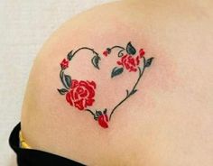 a heart shaped tattoo with roses on the back of her left shoulder and lower arm