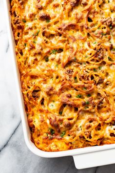 a casserole dish with meat and cheese in it on a marble countertop