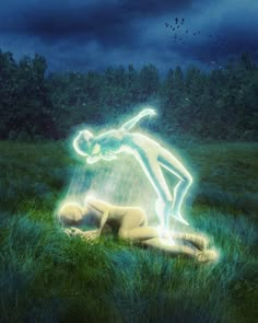 a person laying in the grass with a light painted on their body and arms behind them