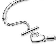 Add a personalized touch to your loved one’s collection with the Pandora Moments Heart T-Bar Snake Chain Bracelet. Hand-finished in sterling silver, this piece is inspired by the classic Pandora Moments T-bar snake chain bracelet. The style features a heart-shaped disc with an open circle on one side to loop the T-bar through to open and close, while the reverse polished side is engravable. Designed to be styled with 10-13 charms, include a unique message for a heartfelt finish. Pandora Heart Bracelet, Solid Silver Bracelets, Dangle Bracelet, Pave Bracelet, Pandora Heart, Bracelet Pandora, Snake Chain Bracelets, Bar Bracelets, Pandora Bracelets