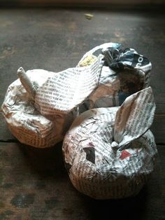 two pieces of newspaper sitting on top of a wooden floor next to each other,