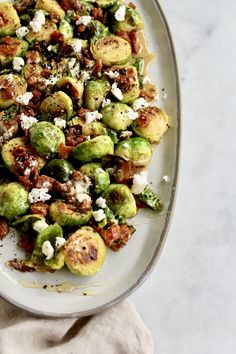 brussel sprouts with bacon and feta cheese on a white plate