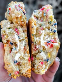 a person holding two pieces of cake with sprinkles