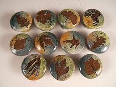 nine buttons with leaves painted on them