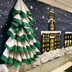 paper christmas trees are on display in front of a wall with buildings and snowflakes