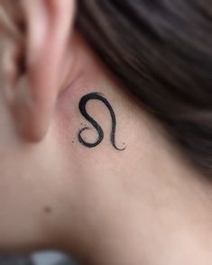 a woman's behind the ear with a small tattoo on her left side neck