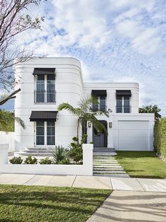 a white house with black shutters and palm trees