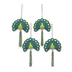 three green and blue peacock fan shaped earrings with tassels hanging from the side