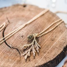 A beautiful matte gold cast cedar branch is paired with a sweet little gold pinecone on a non tarnishing, gold plated chain. Makes a lovely gift for the nature lover and outdoorsy girl. Layer or wear alone as a daily staple! Shiny, non tarnishing, gold plated chain 28" length with 2" extension (71-77 cm) Matte gold finished pendant is 1.45" (37mm) long Gold pinecone is .5" (6mm) long Lobster clasp closure Nickel and lead free Gift ready Nature Inspired Jewelry Necklaces, Nature Themed Jewelry, Hobbit Jewelry, Modest Jewelry, Cedar Branch, Outdoorsy Girl, Twig Jewelry, Nature Inspired Accessories, Pinecone Necklace