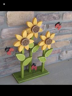 three paper sunflowers with ladybugs on them