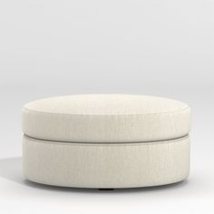 a white round ottoman sitting on top of a floor