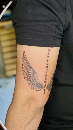 a man with a tattoo on his arm has an angel wing and the words i love you