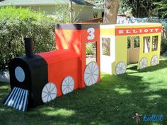 a train made out of cardboard sitting in the grass