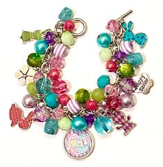 This bright and colorful Easter Bunny themed Charm bracelet is full of Easter cheer. It is made up of various shades of purple, green, hot pink and turquoise beads.  In addition there are 4 single sided enamel bunny charms in 4 coordinating colors, 2 silver tone Happy Easter flower charms and one double sided 18mm bottle charm in the center.  Bracelet is approximately 7.5 inches long. I will be happy to resize the bracelet at no additional charge. Coordinating earrings can be found on a separate Whimsical Multicolor Jewelry With Dangling Charms, Whimsical Multicolor Jewelry With Charms, Whimsical Multicolor Charms Jewelry, Fun Multicolor Charm Jewelry, Themed Multicolor Jewelry With Charms, Multicolor Themed Jewelry With Charms, Multicolor Charms Jewelry For Birthday, Cute Multicolor Jewelry With Lobster Clasp, Multicolor Themed Personalized Jewelry