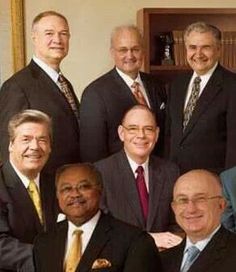 a group of men in suits and ties posing for a photo