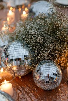 disco ball centerpieces with candles and baby's breath flowers on a table