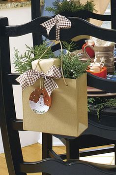 a brown paper bag sitting on top of a wooden chair next to a christmas tree