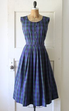 Classic vintage 1950s navy and dark green plaid cotton jumper dress. Made of a soft cotton with a polka dot pattern woven into the textile. Featuring a scoop neckline, functional fabric covered buttons down the front, fitted waist, and full pleated skirt. Has a metal side zipper and belt loops. Would look great styled with a long sleeve blouse beneath. ☾ Info ☽ Material: cotton Label: A David Crystal Fashion Condition: very good vintage condition; I've repaired a 1" rip at the back of the neck and a pea sized rip near the left underarm Freshly laundered and ready to wear! ☾ Measurements ☽ Fits like: small Bust: 34" (can stretch to 35") Waist: 26" Hips: free Length (from shoulder): 45" Bodice length (from shoulder): 16"  *shown unpinned on a 33" bust, 25" waist dress form  ☾ More vintage dr Vintage Sleeveless Plaid Cotton Dress, Vintage Cotton Plaid Dress, Retro Gingham Plaid Cotton Dress, Cotton Vintage Dress With Buttons, 1950s Style Cotton Dress With Buttons, 1950s Cotton Buttoned Dresses, Vintage Cotton Dress With Buttons, Vintage Cotton Gingham Plaid Dress, Vintage Gingham Plaid Cotton Dress