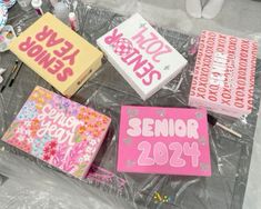 some pink and yellow greeting cards are on the table with other crafting supplies around them