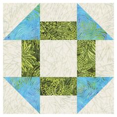 a green and blue quilted design with leaves on it's center piece, in the shape of an arrow