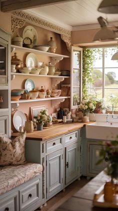 a kitchen filled with lots of counter top space next to a sink and window covered in greenery