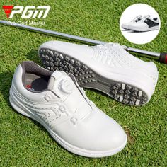 a pair of white golf shoes on the grass with a driver's club in the background