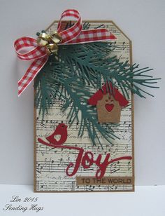 a handmade christmas card with a pine tree and bird on it's tag