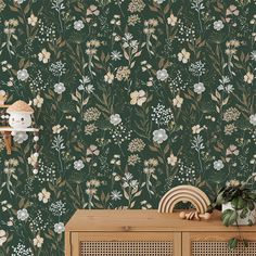 a green wallpaper with flowers on it and a wooden cabinet in the foreground