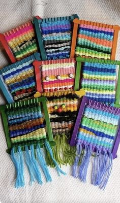 several rows of multicolored loom weavings on a white tablecloth with green handles