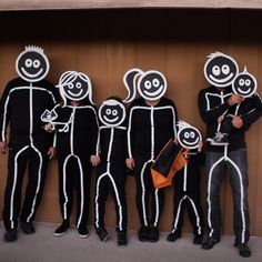 a group of people with faces painted to look like they are standing in front of a wall