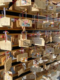 many wooden boxes with chinese writing hanging from the ceiling and decorated with red ribbon bows