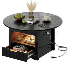 a black table with some books and other items on it's shelf next to a bowl of fruit